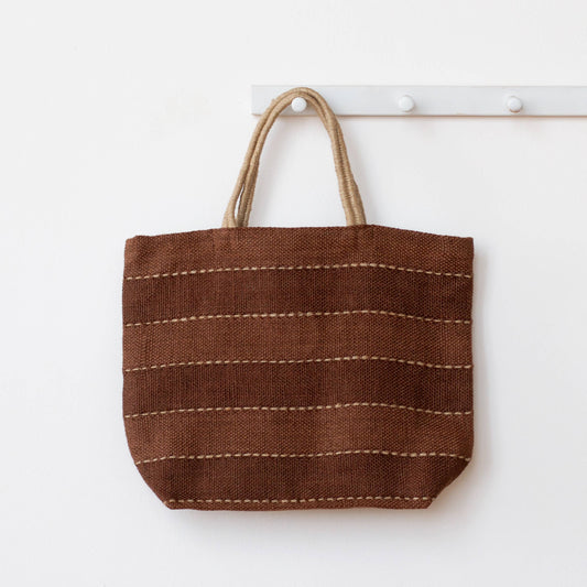 Brown woven tote bag with a handle on a white background